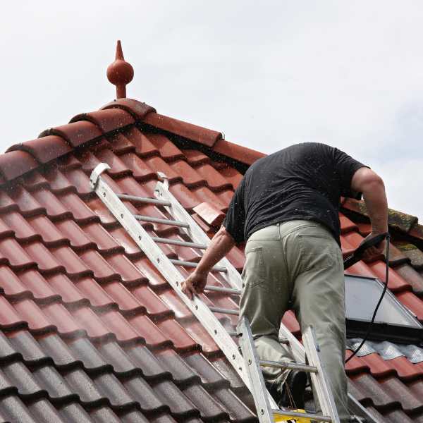 Artisan couvreur travaillant sur un toit en tuiles à Lezay